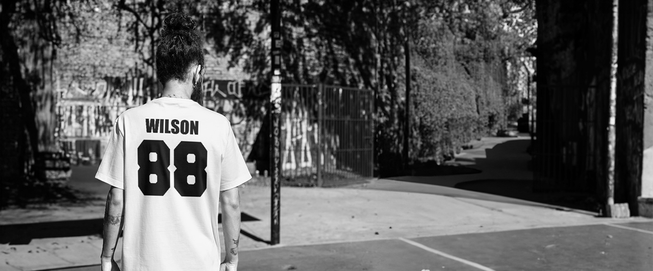 a man wearing a jersey standing in front of a tennis court